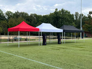 Three Rocket Canopy tents in red, white, and black set up on a sports field in 10x10, 10x15, and 10x20 sizes